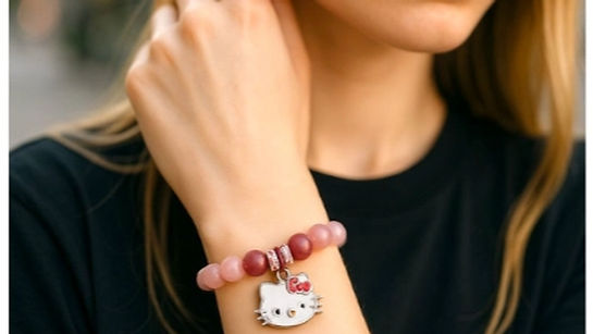 Pink beaded stretch bracelet with a Hello Kitty charm and crystal accent ring.
