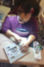 Ingrid focused on arranging beads on a design board while crafting handmade jewelry in her studio