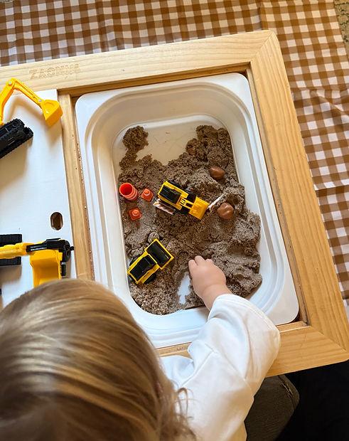 Child exploring a sensory bin during pediatric speech and language therapy to support communication, play, and language development.