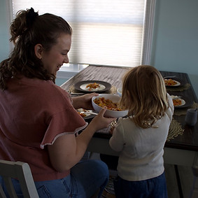 Pediatric feeding therapist working with a young child during an in-home mealtime therapy session.