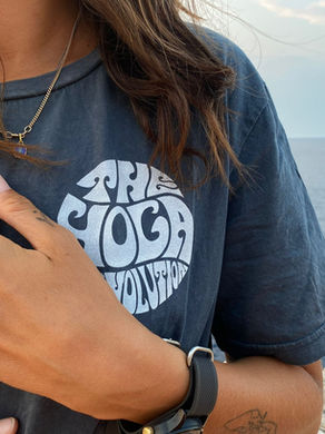 Hand on heart wearing The Yoga Revolution T-shirt