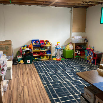 Uncluttered playroom, with toys organized along the walls.