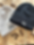 Thumbnail: black Dog Dad and cream Dog Mum embroidered cuffed beanie hats styled on a wooden surface with dog bone treats