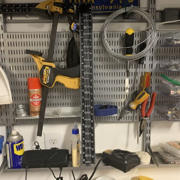 Photograph of tools hanging on a pegboard over a workbench