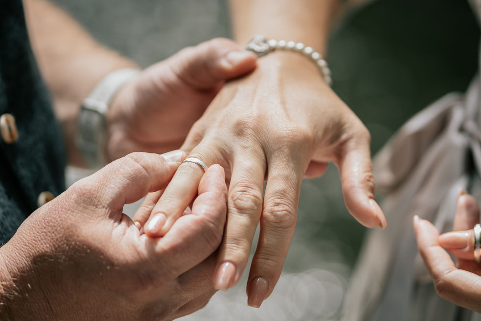 a man putting a wedding ring on a woman 's finger