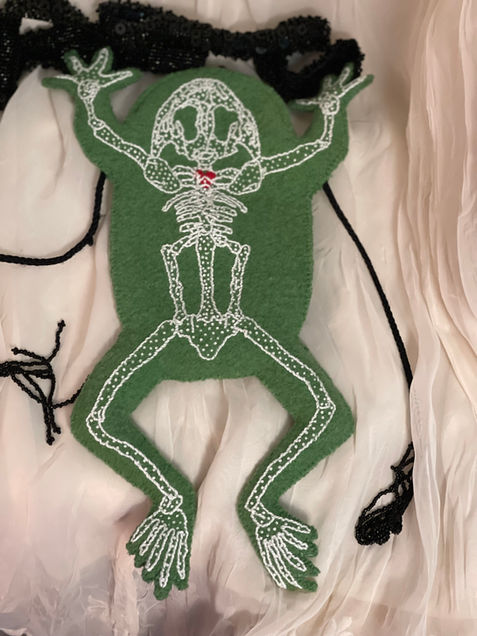 Green Underside of frog purse with white embroidered skeleton and red embroidered heart