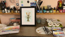 Framed painting of a crawdad on a cluttered art desk.