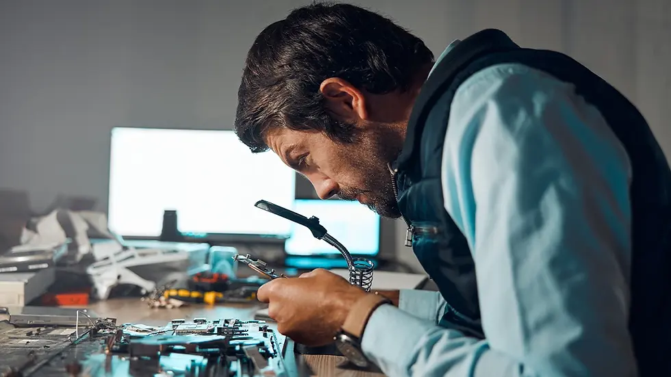 Technician inspecting electronic components on a circuit board under magnification