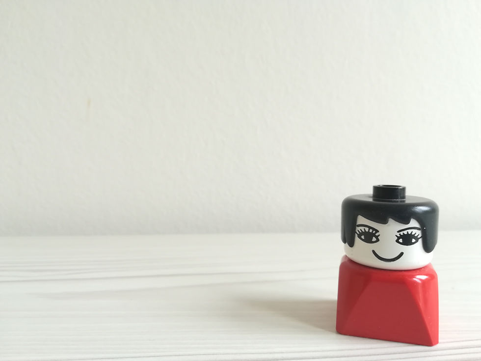 Bildet viser en lego-figur fra 1980-tallet med rød "kjole"