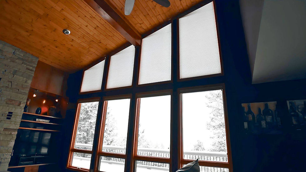 Dramatic floor-to-ceiling windows featuring a series of large uncovered trapezoid windows beneath a sloped wood ceiling in Evergreen CO — Blind Corners and Curves.; Blind Corners & Curves provides sound-dampening specialty shades for homeowners in Aurora, Breckenridge, and Winter Park.;