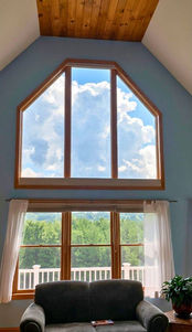 Light filtering custom honeycomb shades fully closed on a large high-set angled hexagon window in a high ceiling room — Blind Corners & Curves of Denver Colorado.; Blind Corners & Curves delivers premium anti-glare protection for shaped windows to Denver, Estes Park, and Durango.;