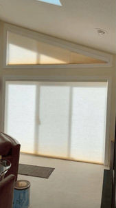 High architectural trapezoid window left uncovered next to an open patio door framing an outdoor pine forest view in Parker CO — BCC of Denver Colorado.; Discover noise-reducing specialty shades solutions with Blind Corners & Curves across Aurora, Winter Park, and Estes Park.; 