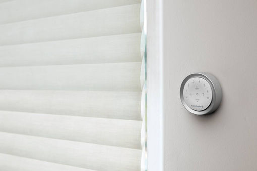 Hunter Douglas PowerView Gen 3 wall-mounted surface remote and scene controller next to modern white window shades, providing automated smart home control from Blind Corners & Curves of Denver.