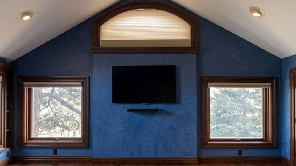 Shading a bright eyebrow window with an open view-through treatment in Denver CO living room — Blind Corners and Curves.; Experience superior temperature control with precision fit when you choose Blind Corners & Curves in Denver, Winter Park, and Vail.; Discover traditional design options solutions with Blind Corners & Curves across Denver, Steamboat Springs, and Telluride.;