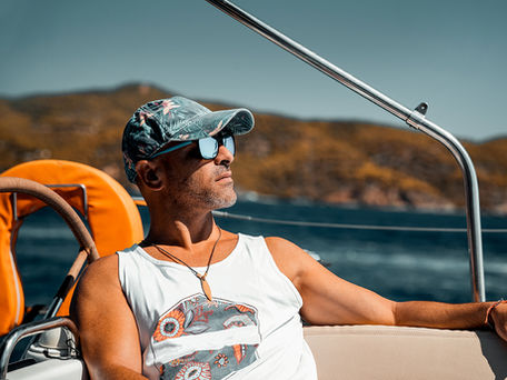 Man wearing sunglasses and hat sitting on a boat