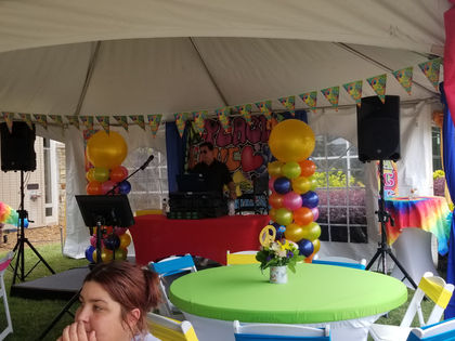DJ under tent surrounded by balloons and 70's theme deco