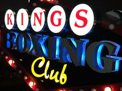 Double-sided illuminated blade sign with front-and-halo-lit channel letters & marquee bulbs
