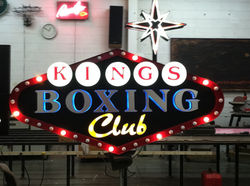 Double-sided illuminated blade sign with front-and-halo-lit channel letters & marquee bulbs