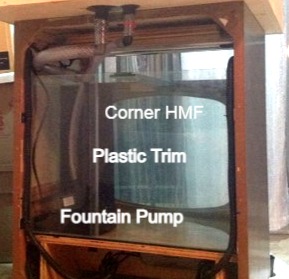 The rear view of an aquarium with a corner HMF filter, labeled to show pump, and trim.