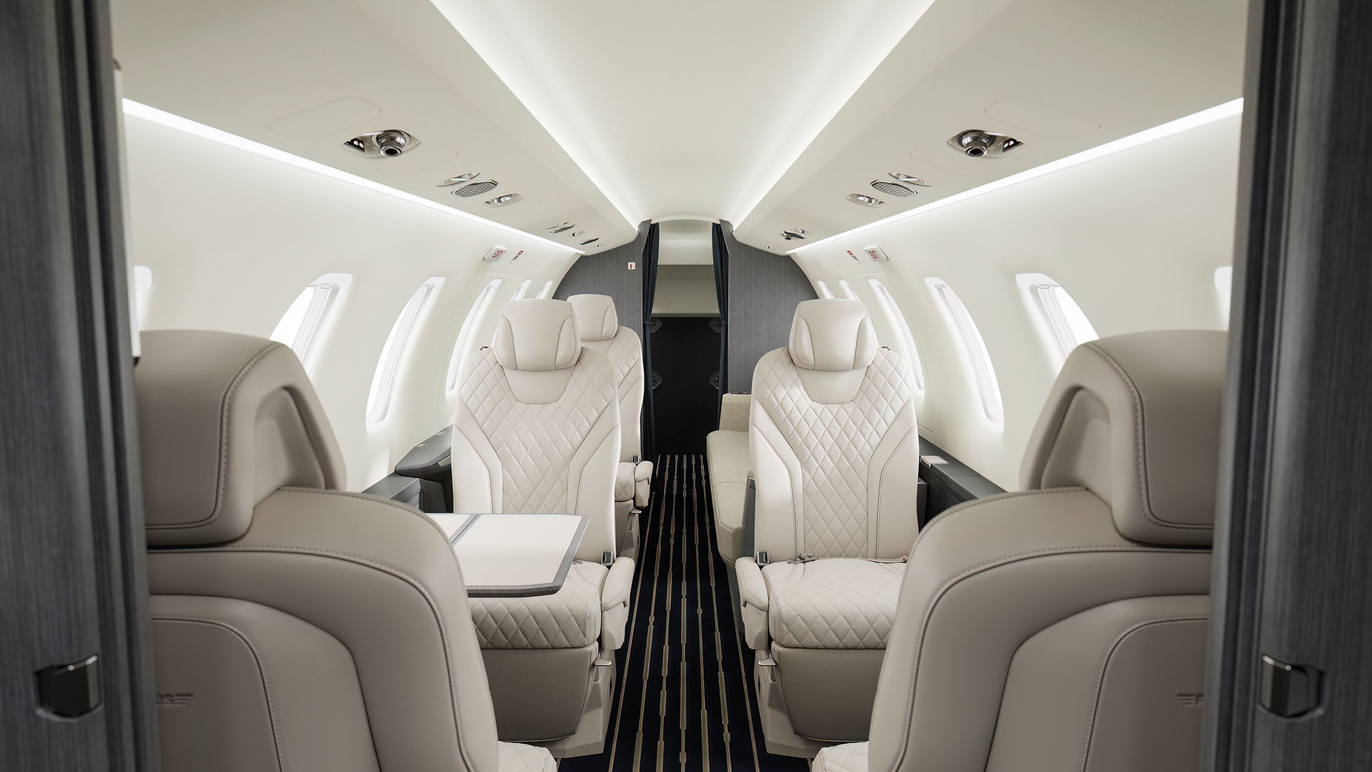 The Pilatus PC-24’s cabin, featuring a complete setup with rotating seats and ample legroom, designed for a premium private aircraft charter experience.