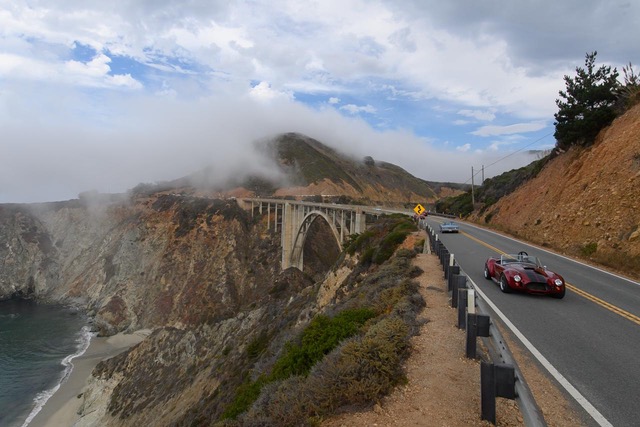 Vintage convertible cruising Big Sur on California’s Highway 1 following arrival with MPI Jet, set against a scenic coastal backdrop