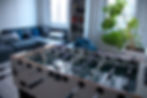 BLUE SILVER Büro Ismaning:
Tischkicker in einem modernen Aufenthaltsraum mit Sofa und Pflanze