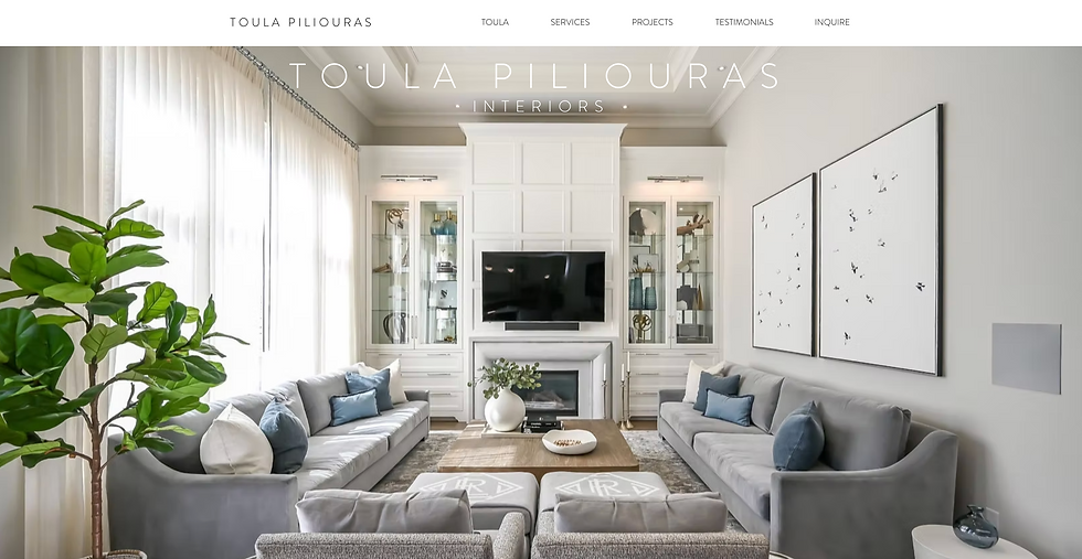Toula Piliouras Interiors website showing a bright modern living room with gray sofas, blue pillows, TV, fireplace, and plants.