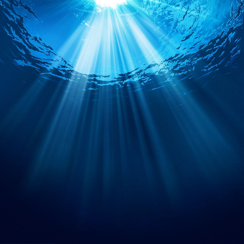 Sunlight beams through blue ocean water, creating a serene underwater scene with rippling surface and deep tranquil hues.