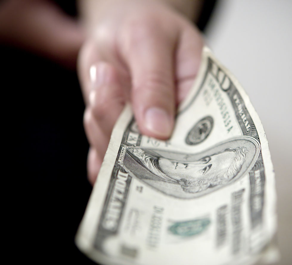 Hand offering a crumpled U.S. ten-dollar bill, close-up. Focus on bill's portrait and details. Background blurred, neutral tone.