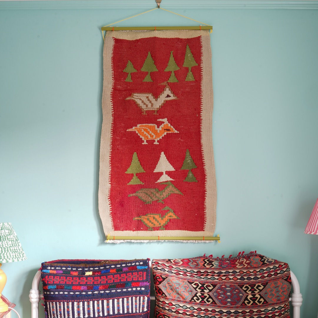 Animal patterned vintage wool hand woven wall hanging tapestry on turquoise bedroom wall