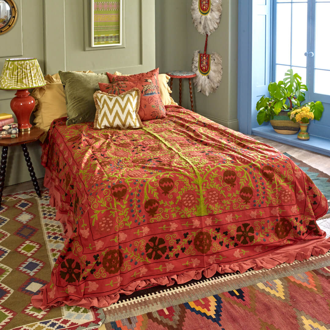 Maximalist interior design, red orange embroidered Suzani bed throw in colourful and patterned boho bedroom