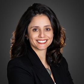 Retrato da psicoterapeuta. Mulher branca com cabelo castanho escuro sorrindo para a foto.