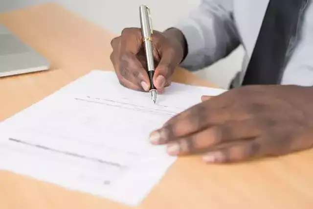 un homme entrain de remplir un papier professionnel