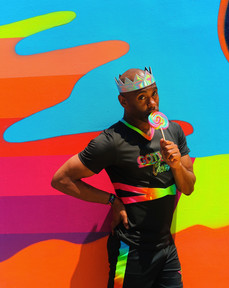 gotham cheer male cheerleader at Bowery Mural in rainbow uniform