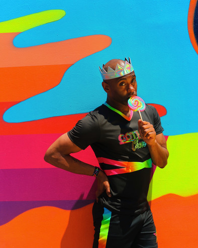 gotham cheer male cheerleader at Bowery Mural in rainbow uniform