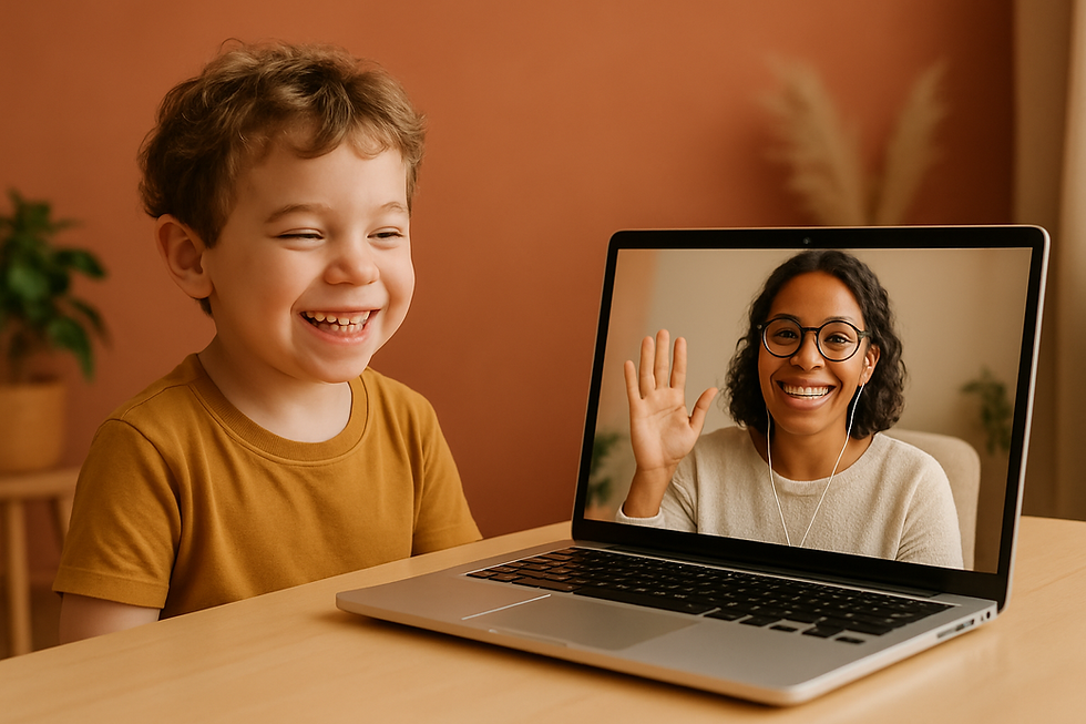 Young child grinning at a laptop screen showing a friendly therapist waving back during speech therapy for autism