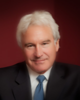 Headshot of a man with white hair, suit, and tie