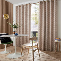 Ready-made light pink patterned curtains on a wooden rail