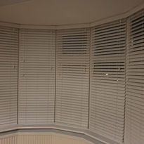 Cream venetian blinds over bay windows