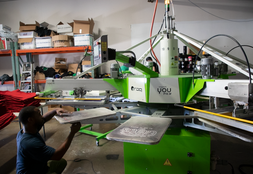 Screenprinter setting up a print job using a ROQ YOU automatic screen printing press