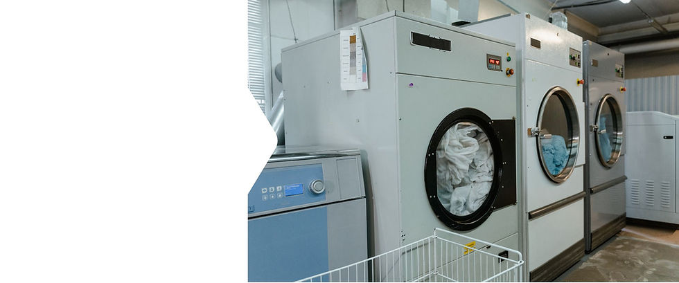 Clean white hotel bed linen folded and stacked at The Textile Service Group commercial laundry in Stockport, Greater Manchester.”