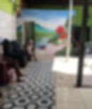 Idoso e pintura de paisagem na parede do ambiente externo do abrigo bom jesus