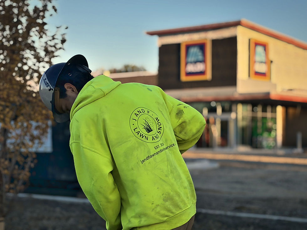 Team J and F crew member in a hi-vis hoodie working at a grocery store property.