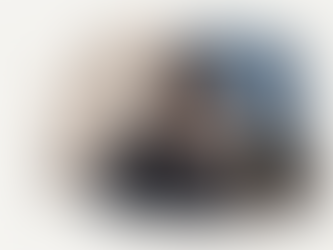 A young 14 year old boy looking at his phone looking sad.