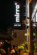 Night view of Mirra Bellevue’s outdoor patio overlooking Lincoln Square South, with guests enjoying drinks and city lights
