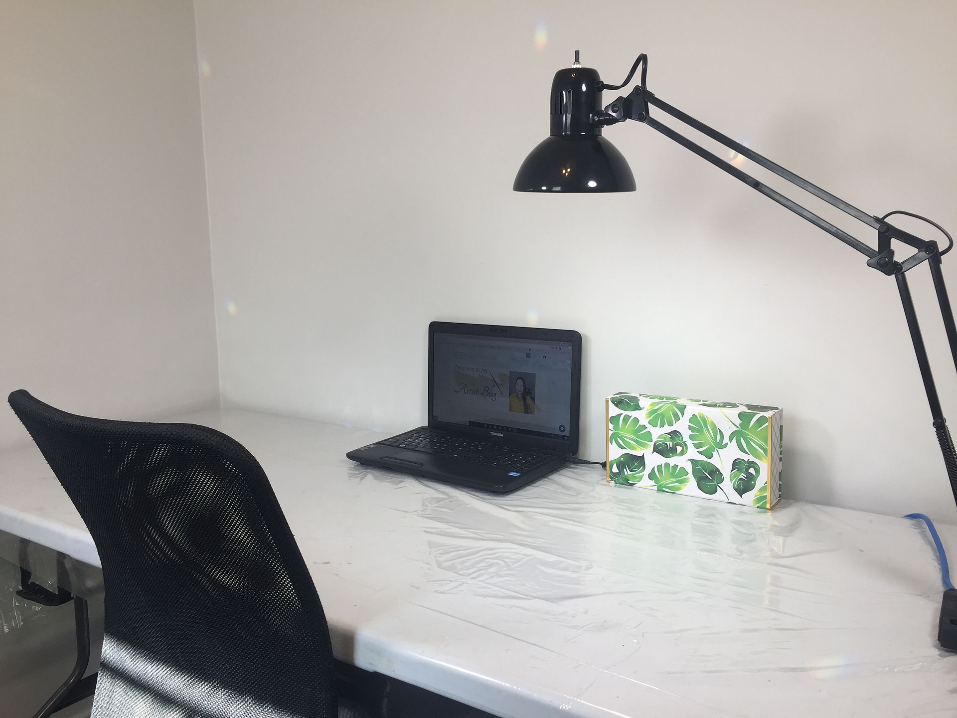 Art-Making Station that has a table, chair and laptop. On the table is a lamp.