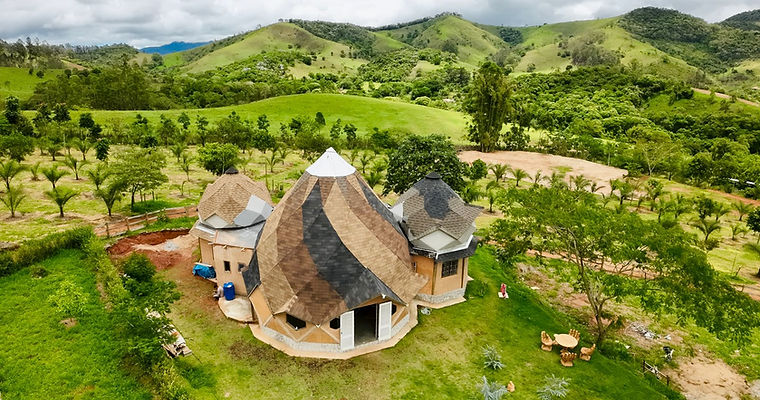 Vista aérea de três estruturas de Zome interligadas na Casa Ohm, exemplificando o design avançado em projetos sustentáveis residenciais na natureza.