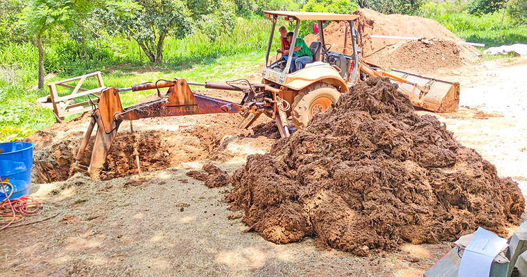 Preparo mecânico de barro para bioconstrução com retroescavadeira para massa de Cob ou Cob usinado no canteiro da Casa Ninho Eckasha, aliando engenharia e bioconstrução.