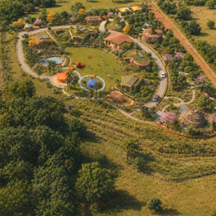 Desenho de ecovila sustentável com masterplan em geometria radial, praça circular central sem automóveis, cursos d'água e design regenerativo.