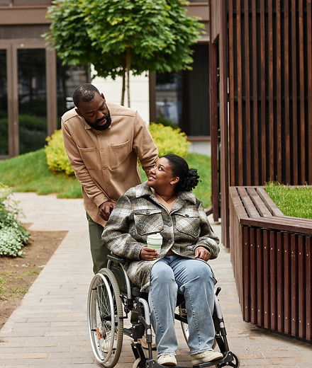 smiling-man-assisting-wife-in-wheelchair-outdoors-2026-01-08-22-11-25-utc.jpg